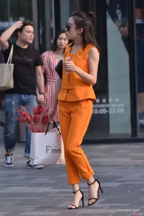 街拍小姐姐橙色的套装，扎一个半丸子头型，显得人很精致！