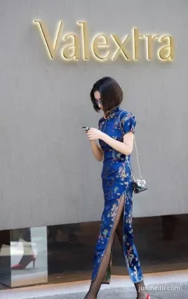 街拍美女一件藍色的旗袍高開叉的設計讓她走路，露出雙腿若隐若現
